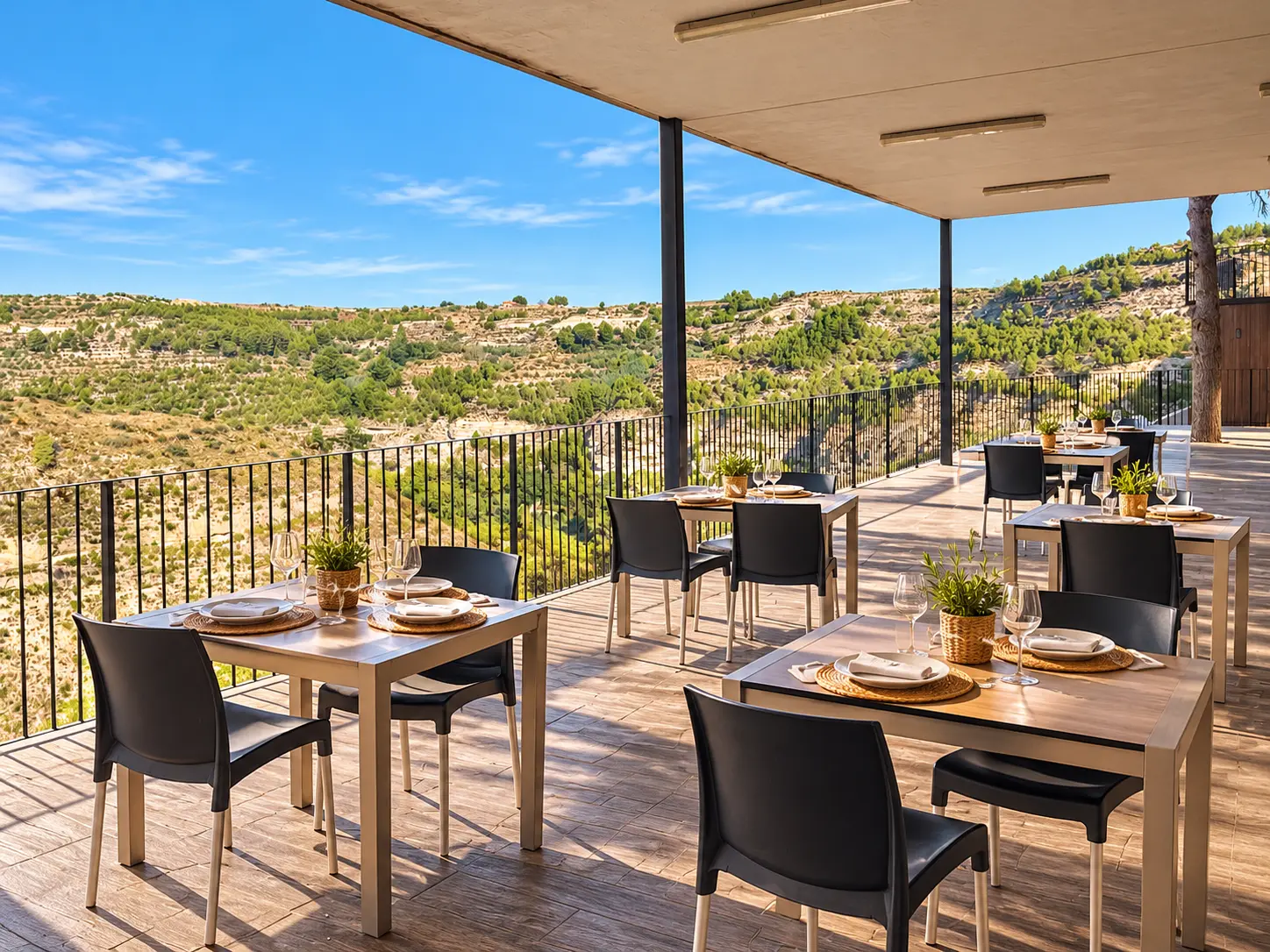 Terraza cubierta del restaurante con las mesas puestas y la hoz del Júcar al fondo